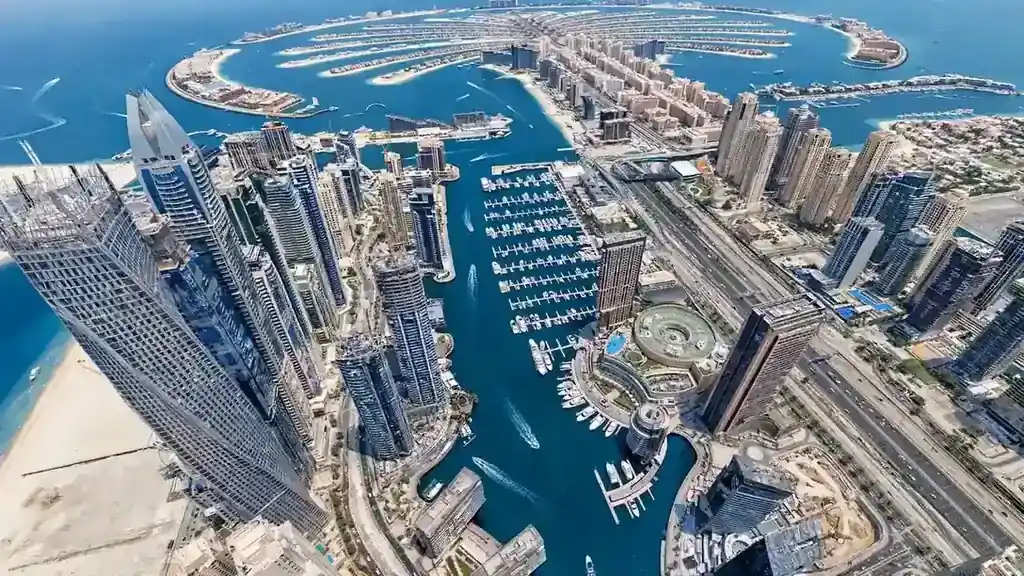 Airbnb Management in Dubai Marina: The Owner's Local Guide Aerial view of Dubai Marina towers curving toward Palm Jumeirah